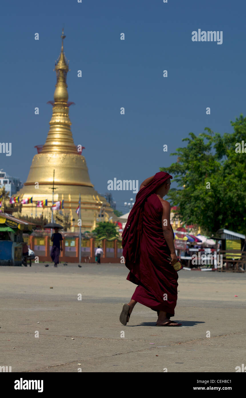 Mönch zu Fuß vor einem goldenen Stupa, Rangun, Myanmar Stockfoto