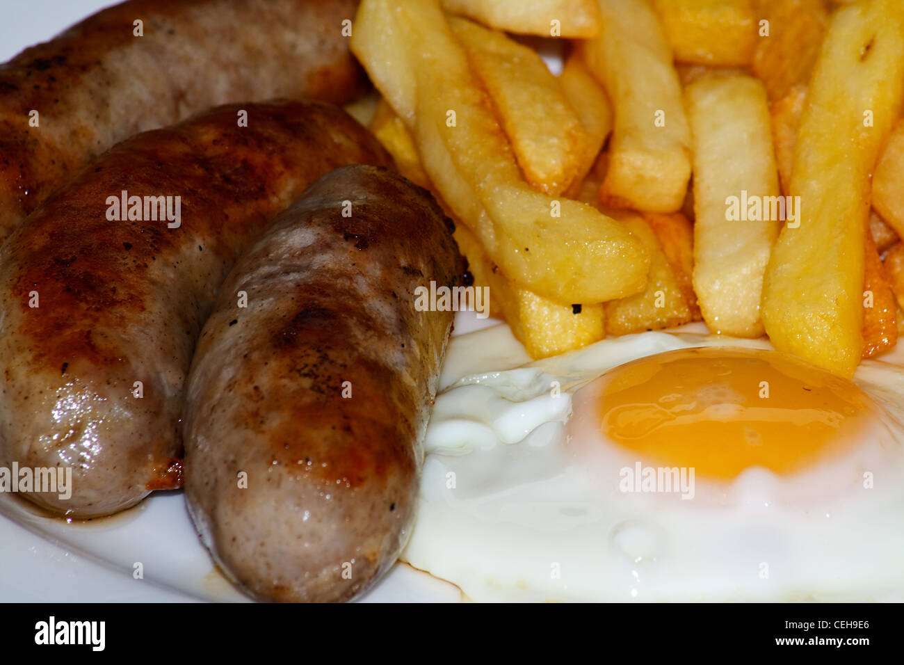 Nahaufnahme von Wurst, Ei und Chips. Ein traditionelles britisches Gericht Stockfoto