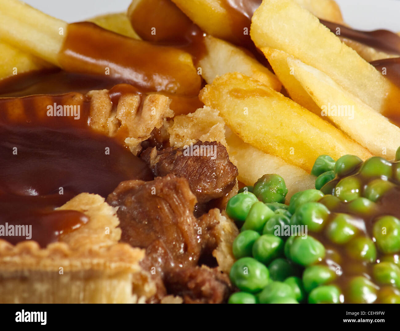 Nahaufnahme von Steak Pie und Chips mit Erbsen und Soße. Ein traditionelles britisches Gericht Stockfoto