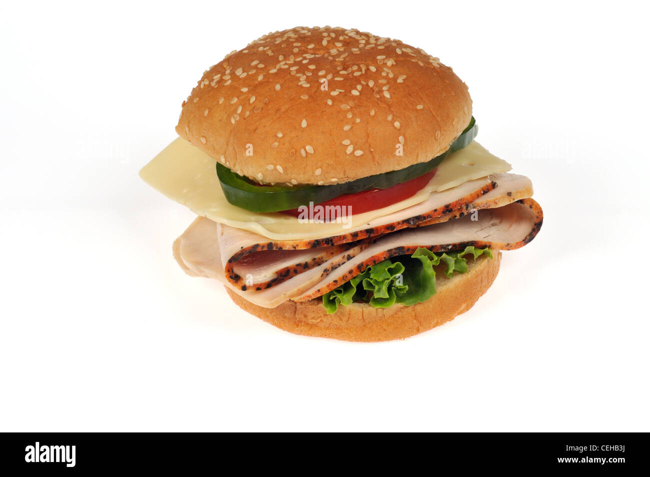 In Scheiben geschnitten Türkei mit Käse, Rollen Salat, Tomaten und grünem Pfeffer Sandwich auf Sesam auf weißem Hintergrund Ausschnitt. Stockfoto