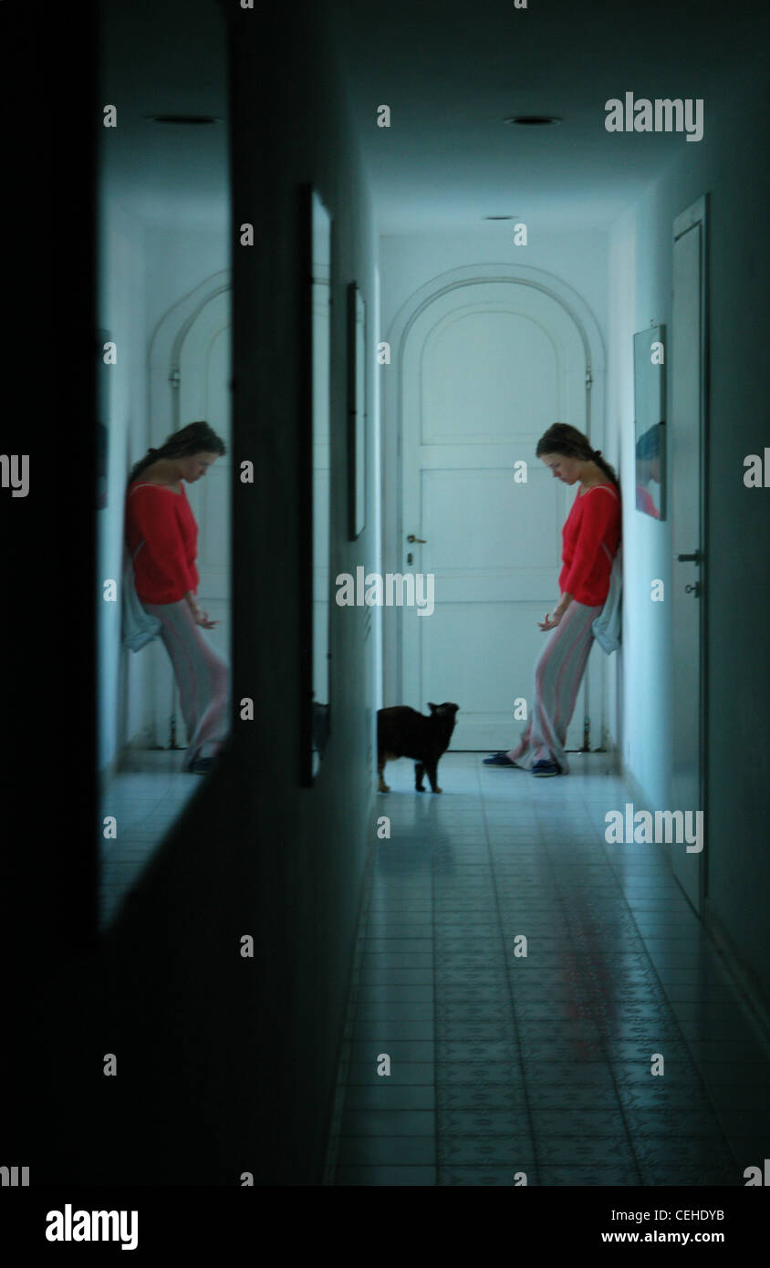 Mädchen in roten und schwarzen Katze in das Licht am Ende eines dunklen Korridors Stockfoto