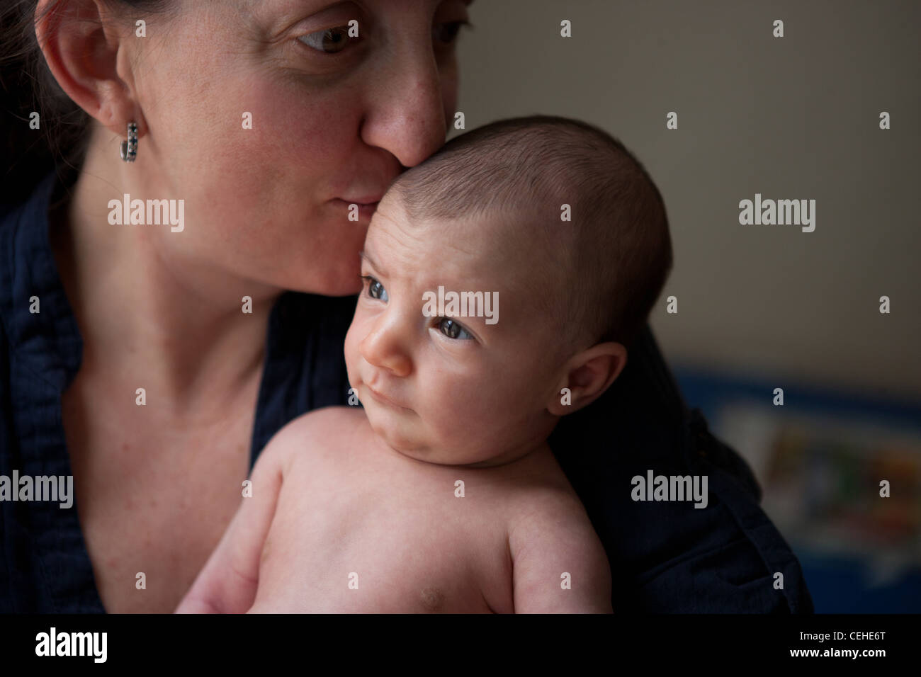 Nahaufnahme einer vierzig Jahre alten Mutter küssen ihre neugeborene Tochter. Stockfoto
