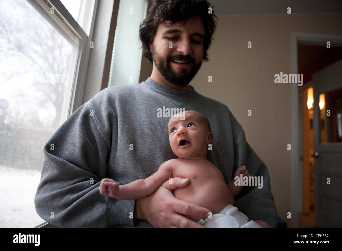 Vater sein glücklich neugeborenes Mädchen, Blick aus Fenster zu Hause halten. Stockfoto