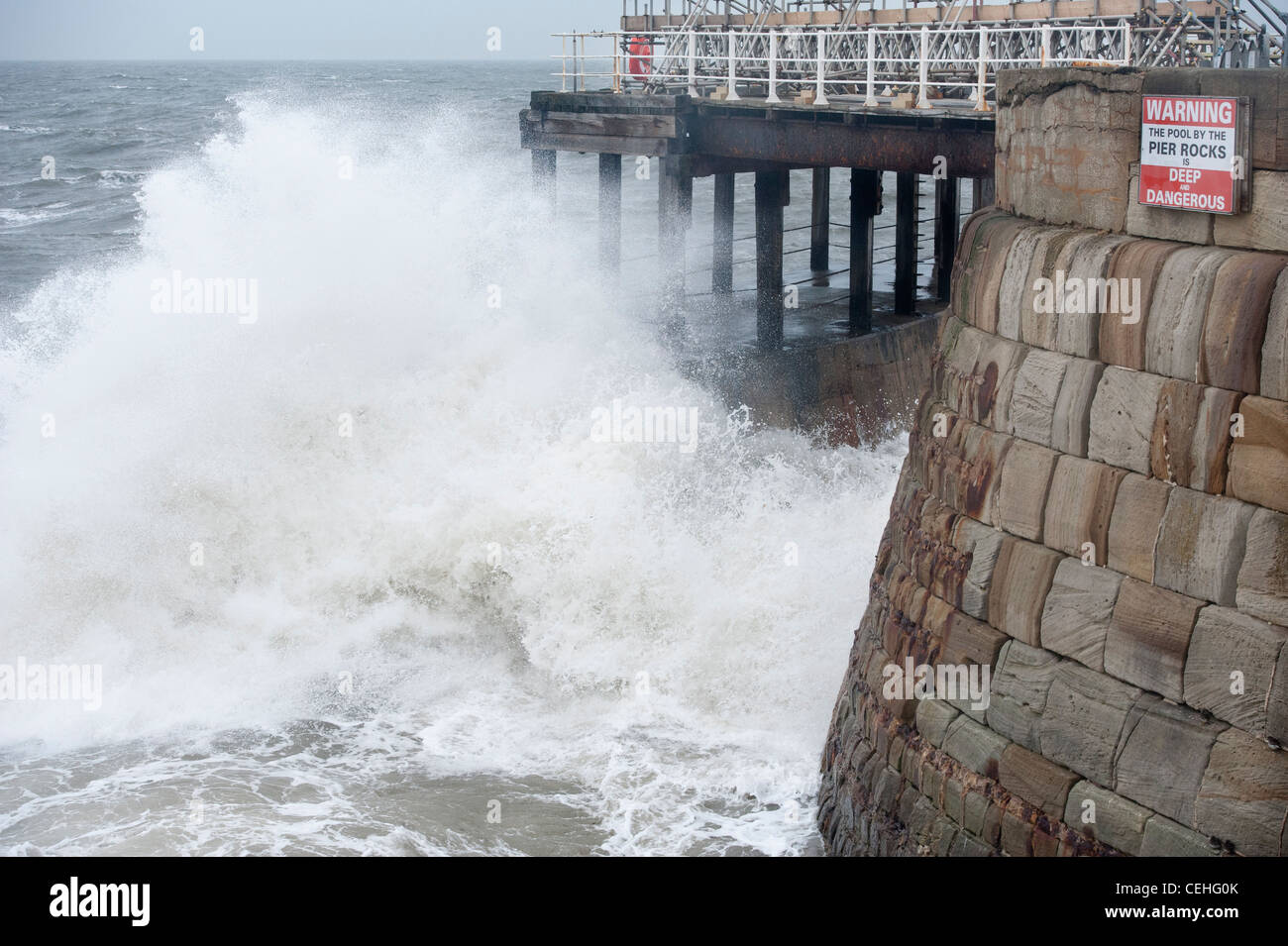 Wellen, die unter dem West Pier in Whitby Stockfoto