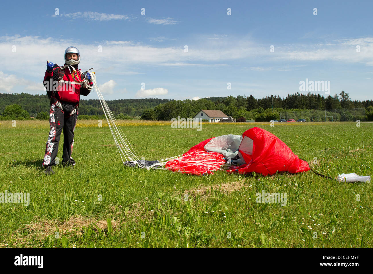 Fallschirmspringer freut sich über fünfzig nach ein erfolgreichen Fallschirm springen. Er ist seinem Baldachin zusammenkommen und lächelnd in seinem Helm. Stockfoto