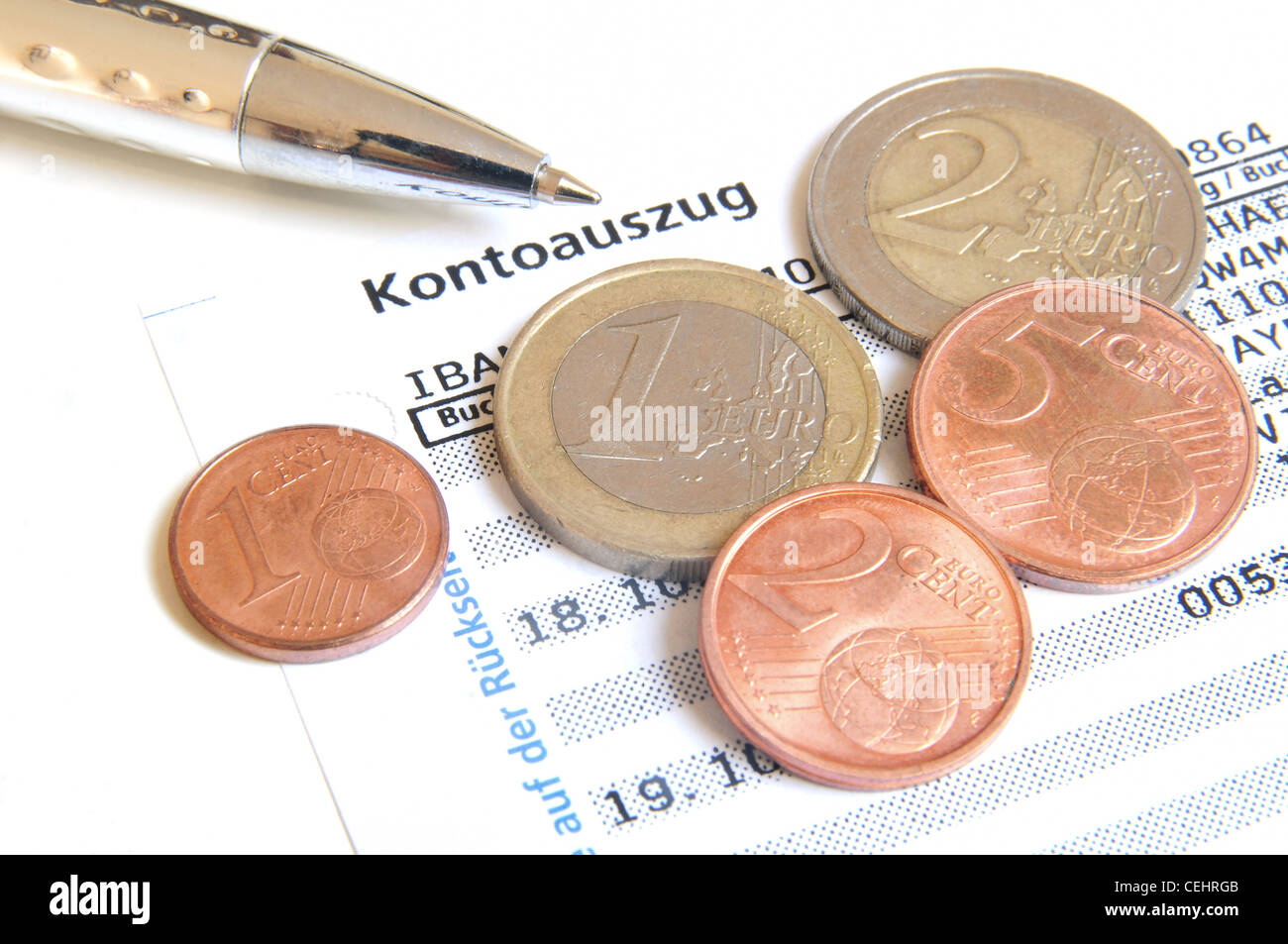 Euro-Münzen und Kugelschreiber auf einen Kontoauszug Stockfoto