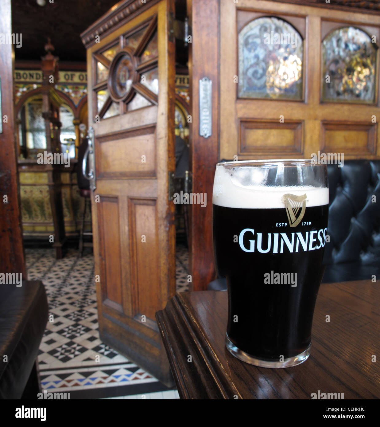 In der Victorian Crown Saloon Bar, Belfast, mit einem Pint Guinness Stout, 46 Great Victoria St, Belfast, County Antrim, Nordirland, BT2 7BA Stockfoto