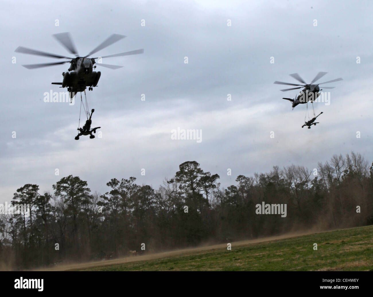 CAMP LEJEUNE - zwei CH-53E Super Hengste mit Marine Medium Tiltrotor Squadron VMM-261 (verstärkt), 24. Marine Expeditionary Unit Airdrop M-777 Haubitzen hier, 14. Februar 2012 während der Ausladung Verfahren für ihre Zertifizierung Übung (CERTEX). Der 24. MEU führt CERTEX mit der Iwo Jima Amphibian Ready Group durch, die vom 27. Januar bis 17. Februar geplant ist.Diese beinhaltet eine Reihe von Missionen, die die Einheit für ihren bevorstehenden Einsatz bewerten und zertifizieren sollen. Die CH-53E Super Hengste sind aus der Marine Corps Air Station New River. Stockfoto