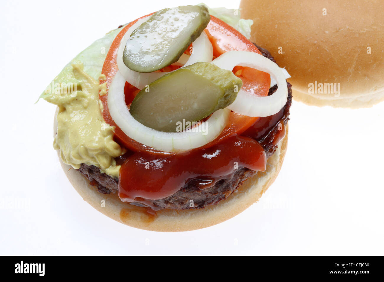 Ernährung, Fast-Food. Hamburger, Fleischkäse mit Zwiebeln, Gurken, Senf, Ketchup, Brot Rollen. Stockfoto