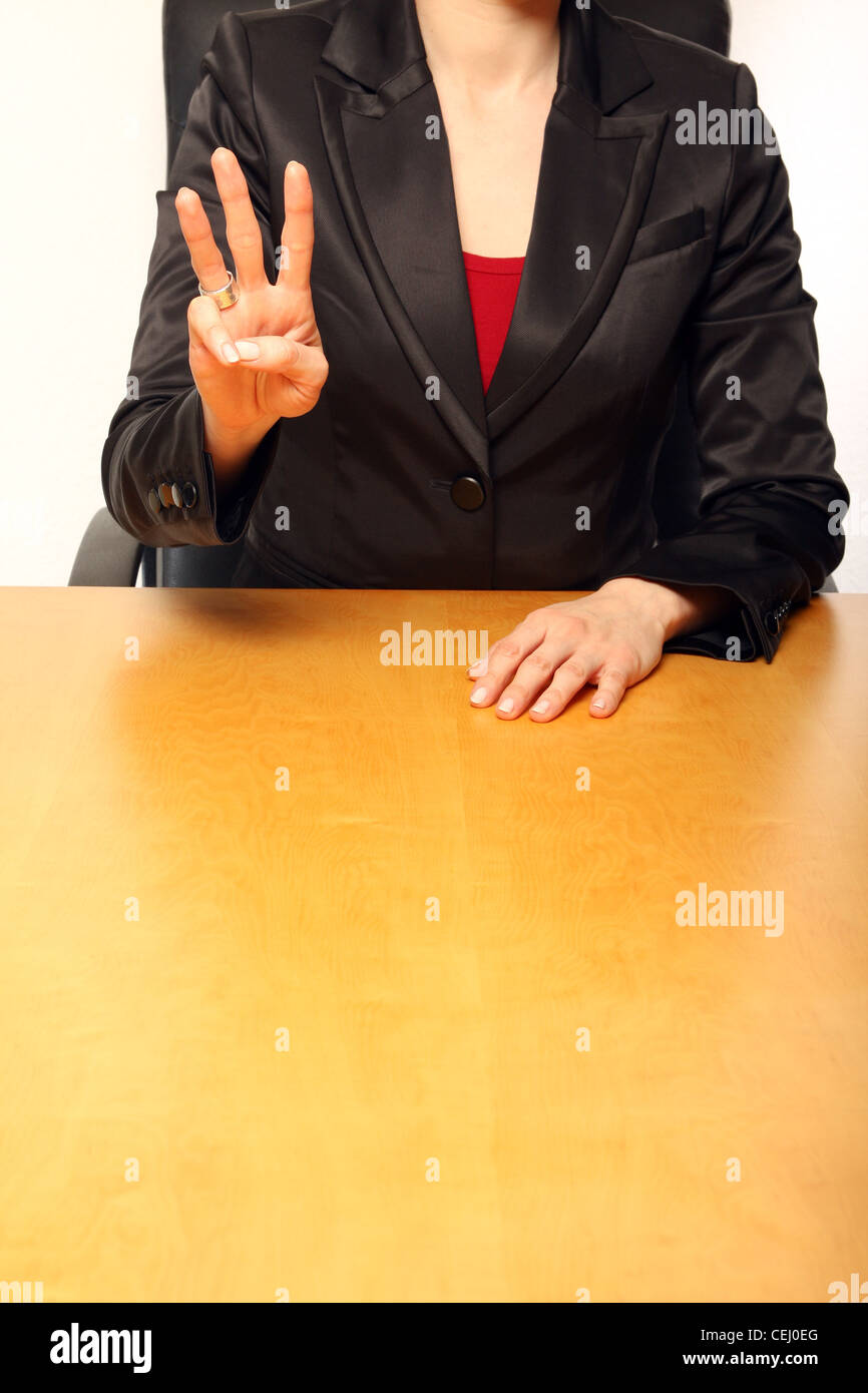 Blick auf eine Geschäftsfrau am Schreibtisch sitzt und mit den Fingern zählen Stockfoto