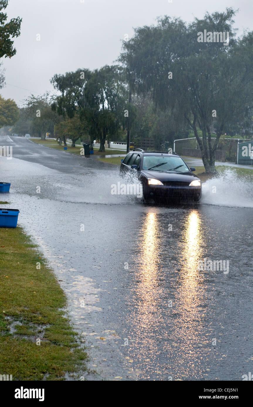 Überfluteten Straße mit Auto fahren durch Wasser Stockfoto