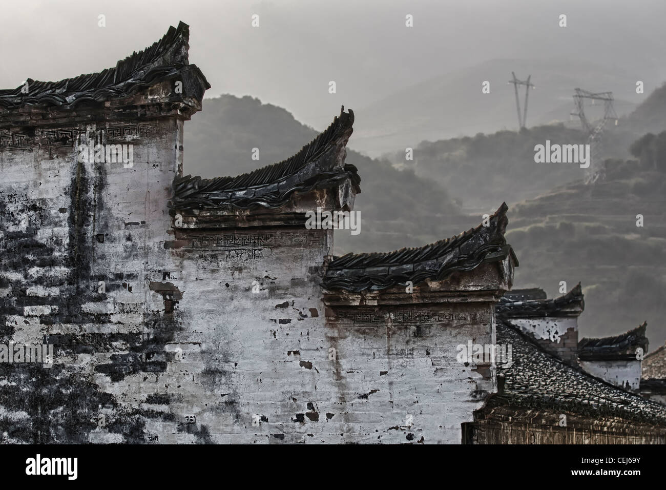 Eine chinesische Hui Stil Wand- und Dachelemente wie Pferdeköpfe geformt und harmonisiert mit schwarzen und weißen Farbe, Berge im Hintergrund Stockfoto