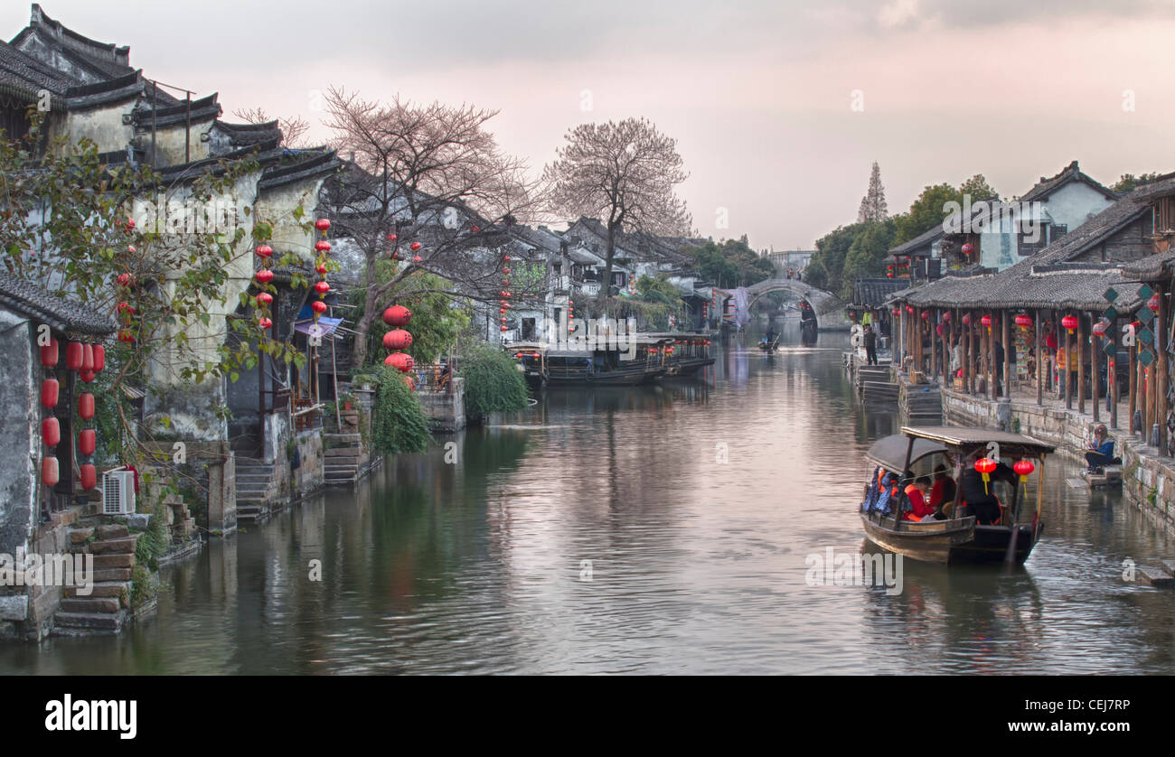 Die Dämmerung auf der Wasserstraße Stadt Xitang, Jiashan, Zhejiang, China. Traditionelle Häuser mit roten Laternen säumen die Ufer des Kanals. Stockfoto