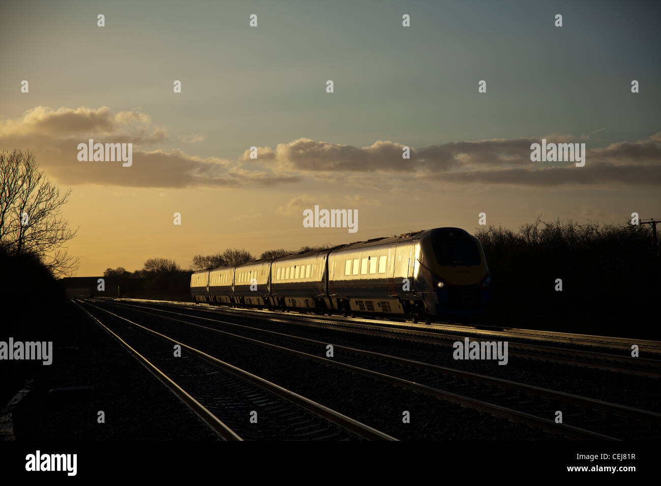 East Midlands Züge Klasse 222 Meridian fängt am frühen Morgen Glint Sonnenlicht bei Cossington Fuß überqueren. Stockfoto