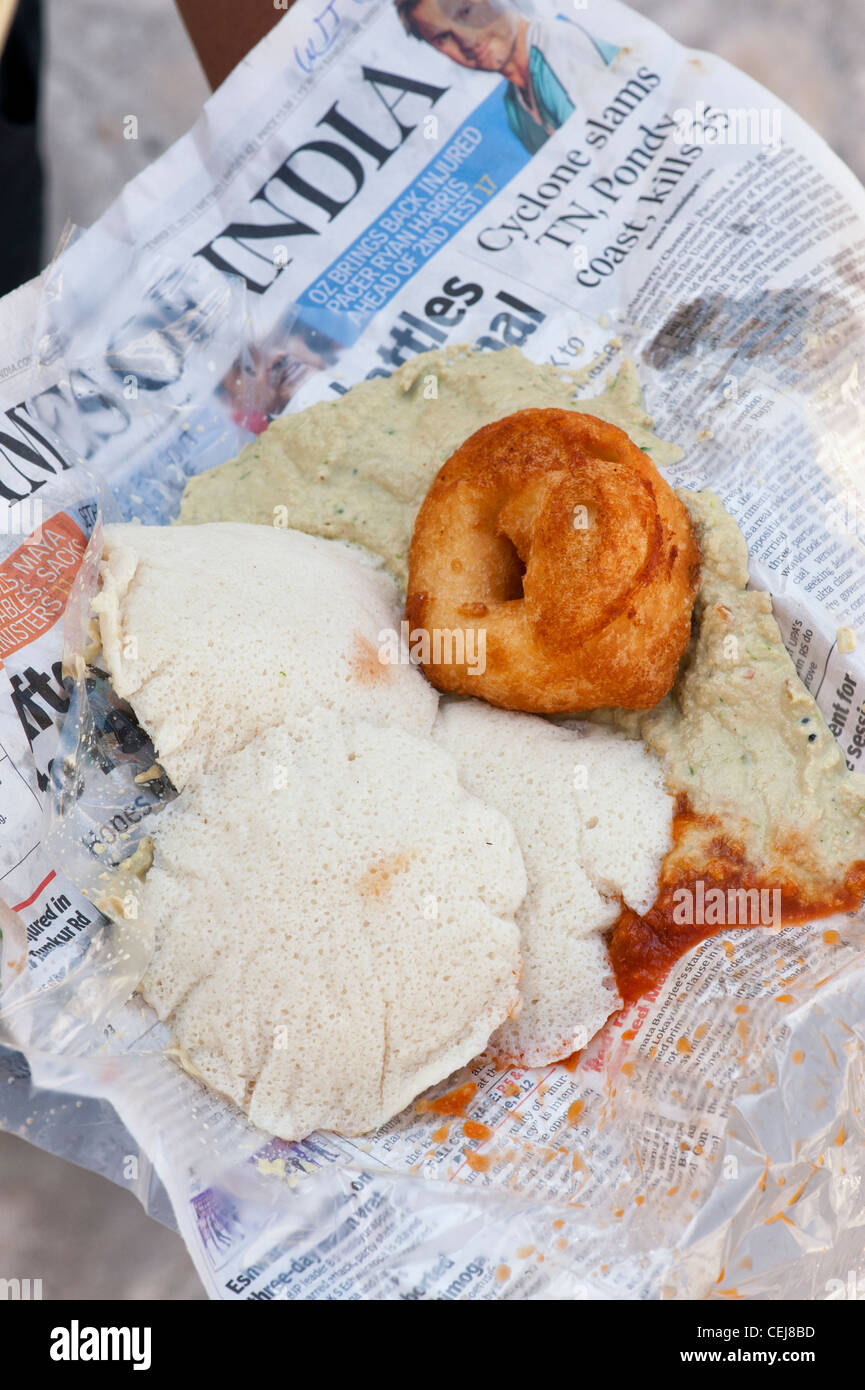 South Indian Frühstück mit Idli, Wada mit einer pikanten Chutneys in Zeitungspapier eingewickelt. Andhra Pradesh, Indien Stockfoto