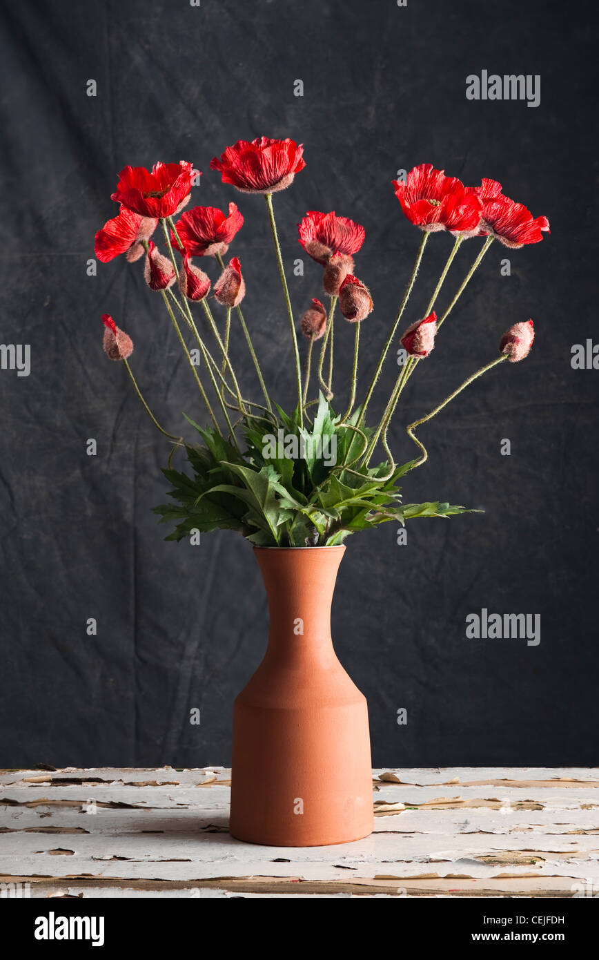 Eine Keramik-Vase mit künstlichen roten Mohnblumen Stockfoto