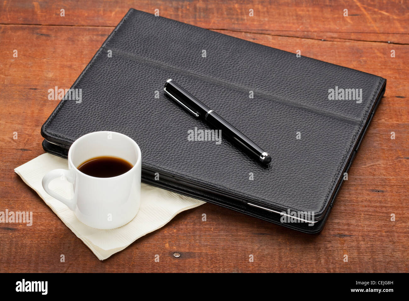 Tablet-Computer im Lederetui mit Stylus-Stift und eine Tasse Espressokaffee auf alte alte Grunge Holz Tisch Stockfoto