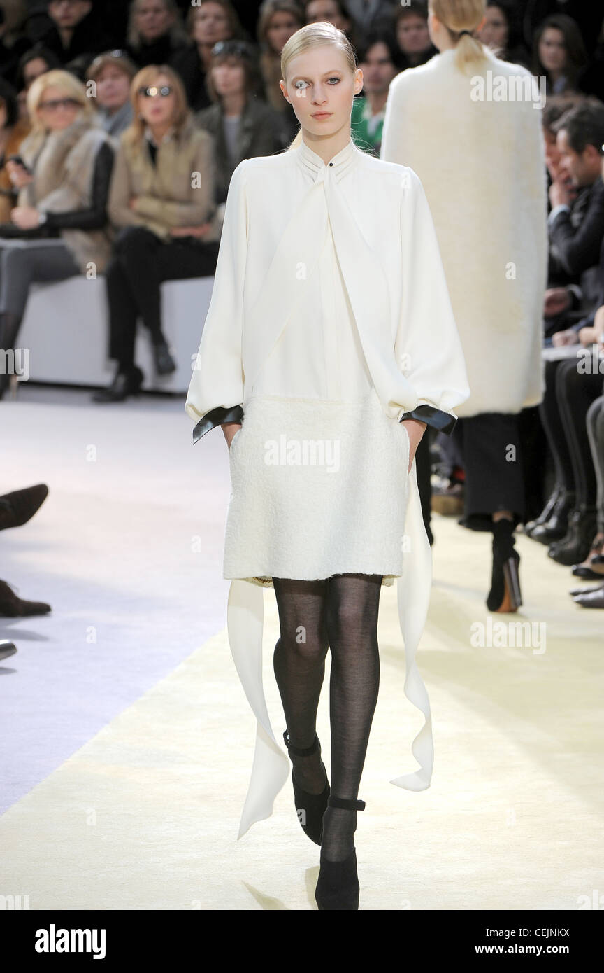 Celine Paris bereit zu tragen-Herbst-Winter-weiße Bluse schwarz Manschetten, weiße Linie Rock, schwarze Strumpfhose und schwarze Schuhe Knöchel Stockfoto