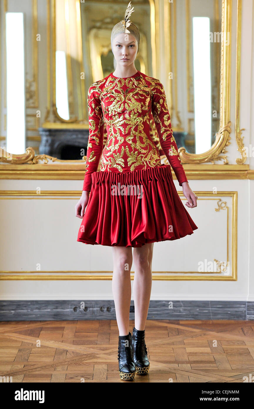 Alexander McQueen Paris bereit zu tragen Herbst Winter endgültig zeigen rote Knie Länge Kleid gold Stickerei und Plissee, schwarze Knöchel Stockfoto