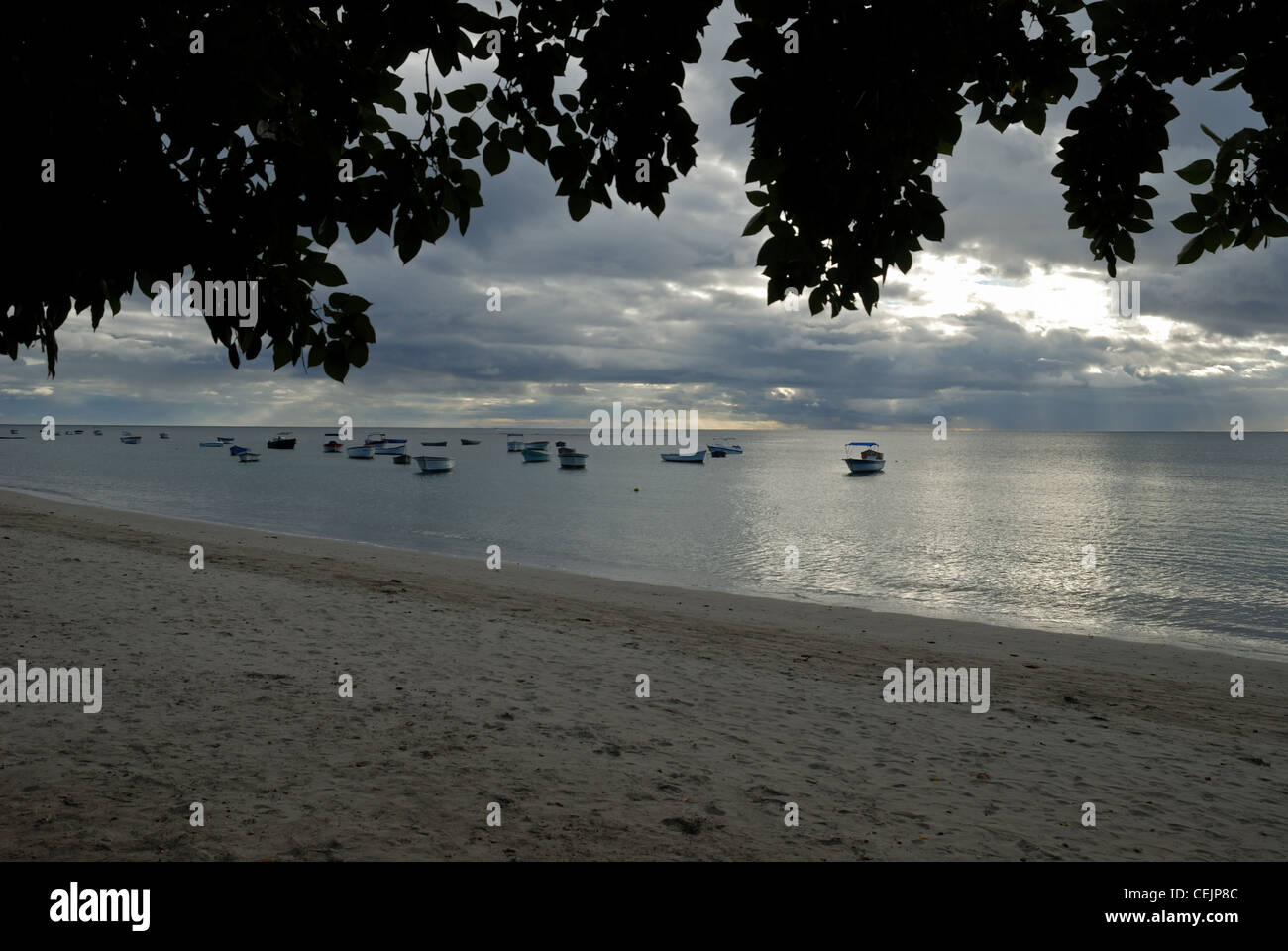 Strand und Boote in der Ferne in der Abenddämmerung. Mauritius. Stockfoto