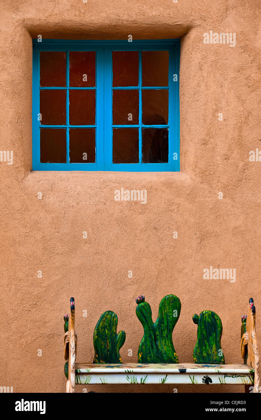 Ein blaues Fenster auf Adobe strukturierte Wand mit Kakteen Dekoration an der Vorderseite. Stockfoto