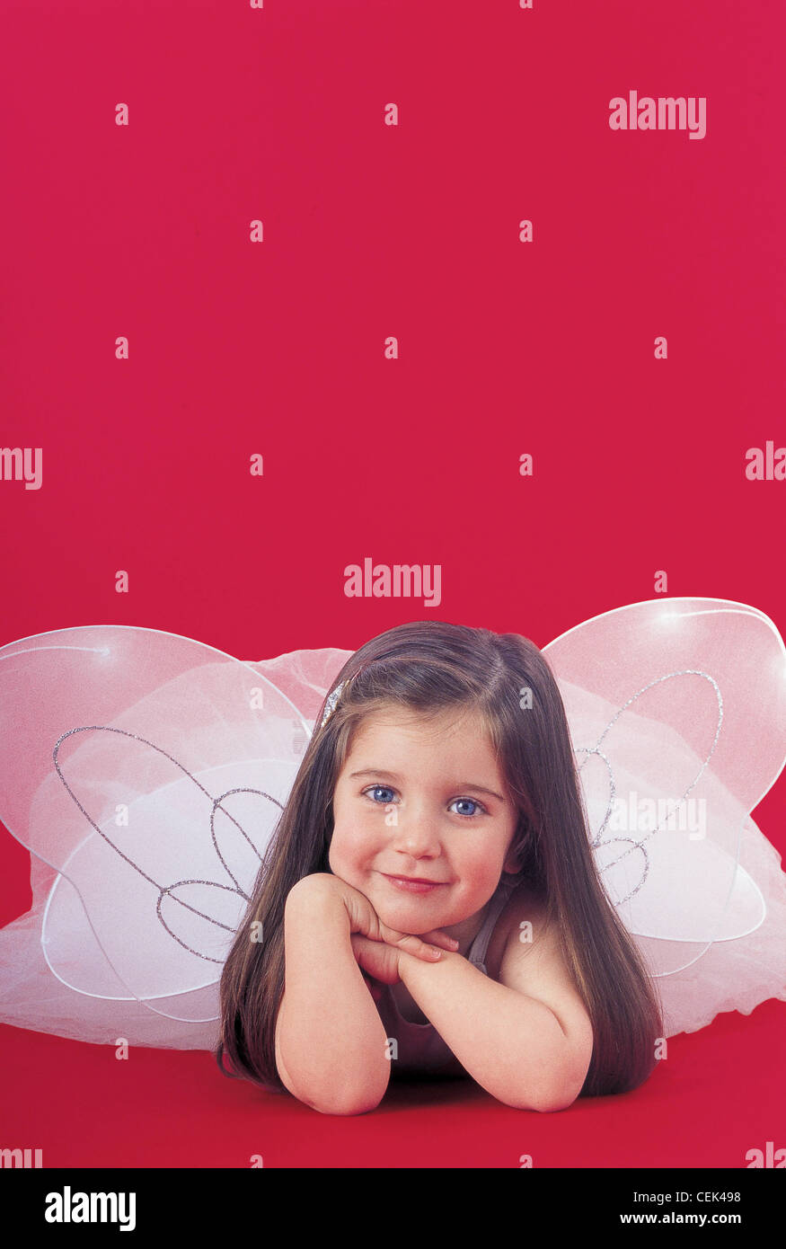 Kind in Fee Flügel roten Hintergrund R Baby Medien Stockfoto