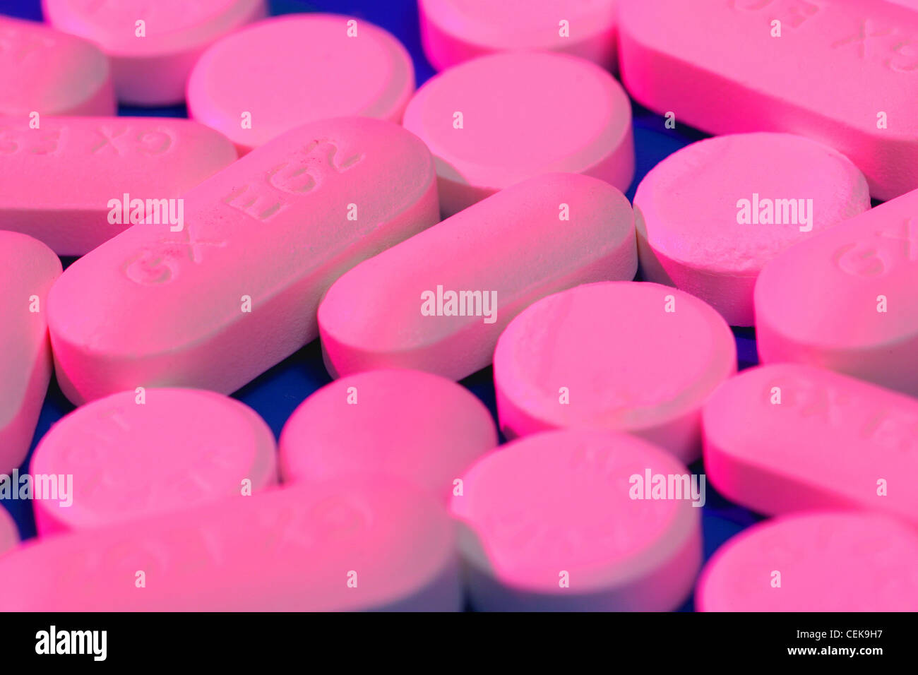 Rosa länglich geformte Tabletten und Runde rosa Tabletten auf blauem  Hintergrund Stockfotografie - Alamy