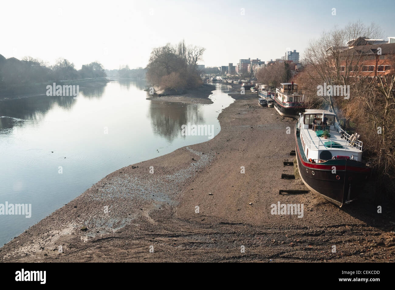 Winter-Ebbe auf der Themse, London, mit Hausbooten am Ufer Brentford. Von Kew Bridge auf der Suche nach Westen betrachtet. Stockfoto