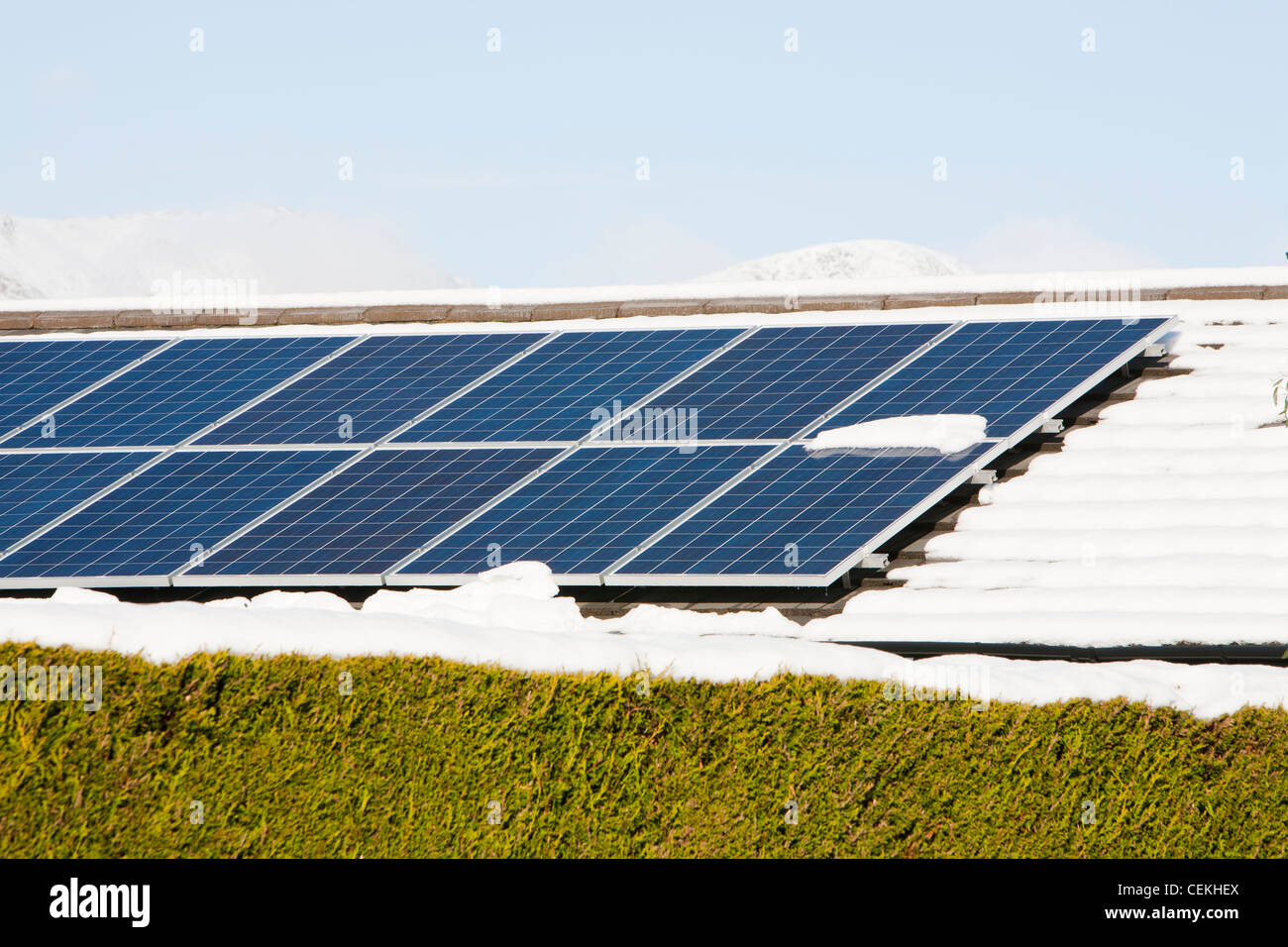 Sonnenkollektoren auf einem Haus Dach in Ambleside im Schnee, Lake District, Großbritannien. Stockfoto