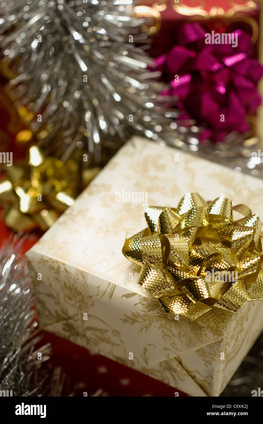 Weihnachtsgeschenk verpackt, Creme und Gold Toile De Jouy Stil Papier gold Bug, Silberflitter, rosa und goldenen Bögen im Hintergrund Stockfoto