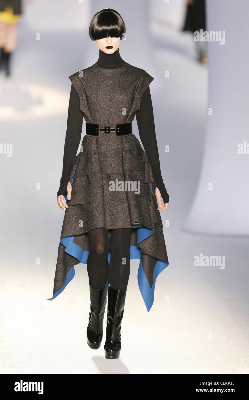 Modell trägt eine graue Tweed-Tunika-Kleid mit Rüschen-Details und ein Taschentuch Saum mit leuchtend blauen Details Stockfoto