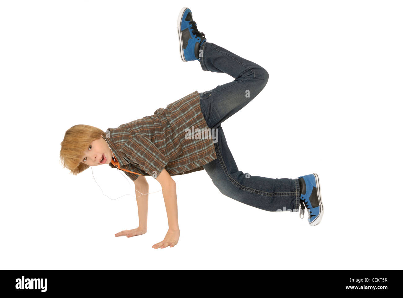 Elfjähriger Junge tragen Kopfhörer, MP3-Player anhören und tanzen auf dem Boden. Stockfoto