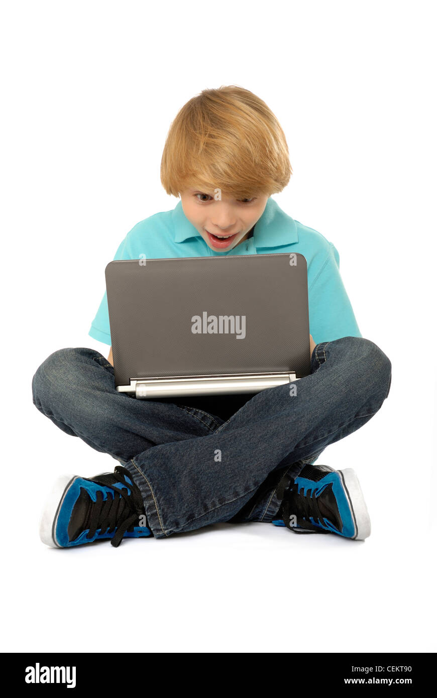 Elf Jahre alter Junge sitzt und Laptopcomputer. Stockfoto