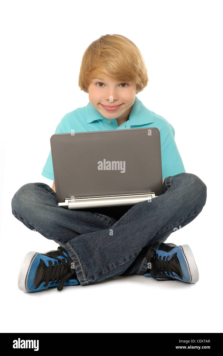Elf Jahre alter Junge sitzt und Laptopcomputer. Stockfoto