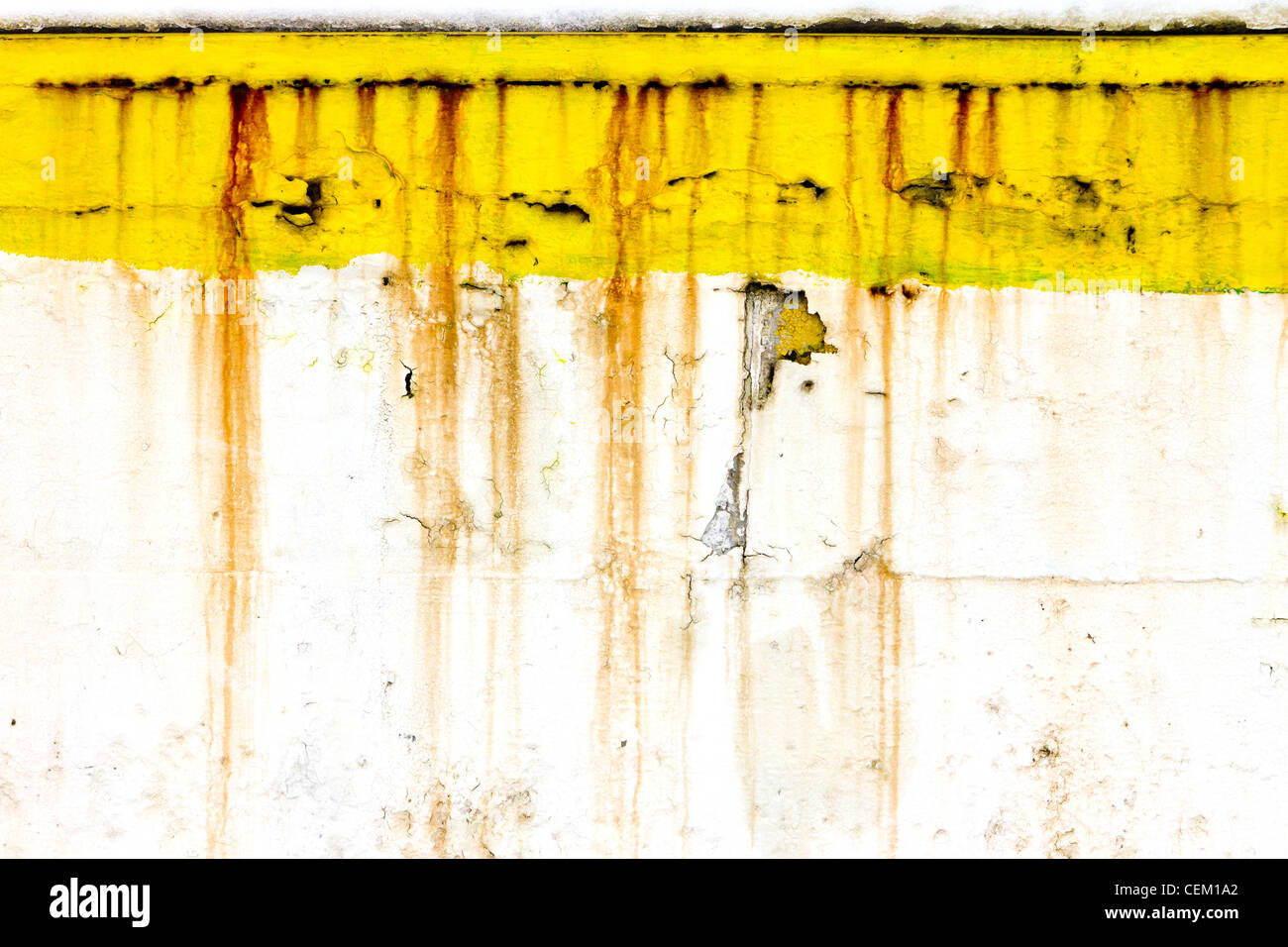 Grunge alte Mauer mit peeling-gelben Farbe und tropft rostige Linien schafft einzigartige Hintergrundtextur. Stockfoto