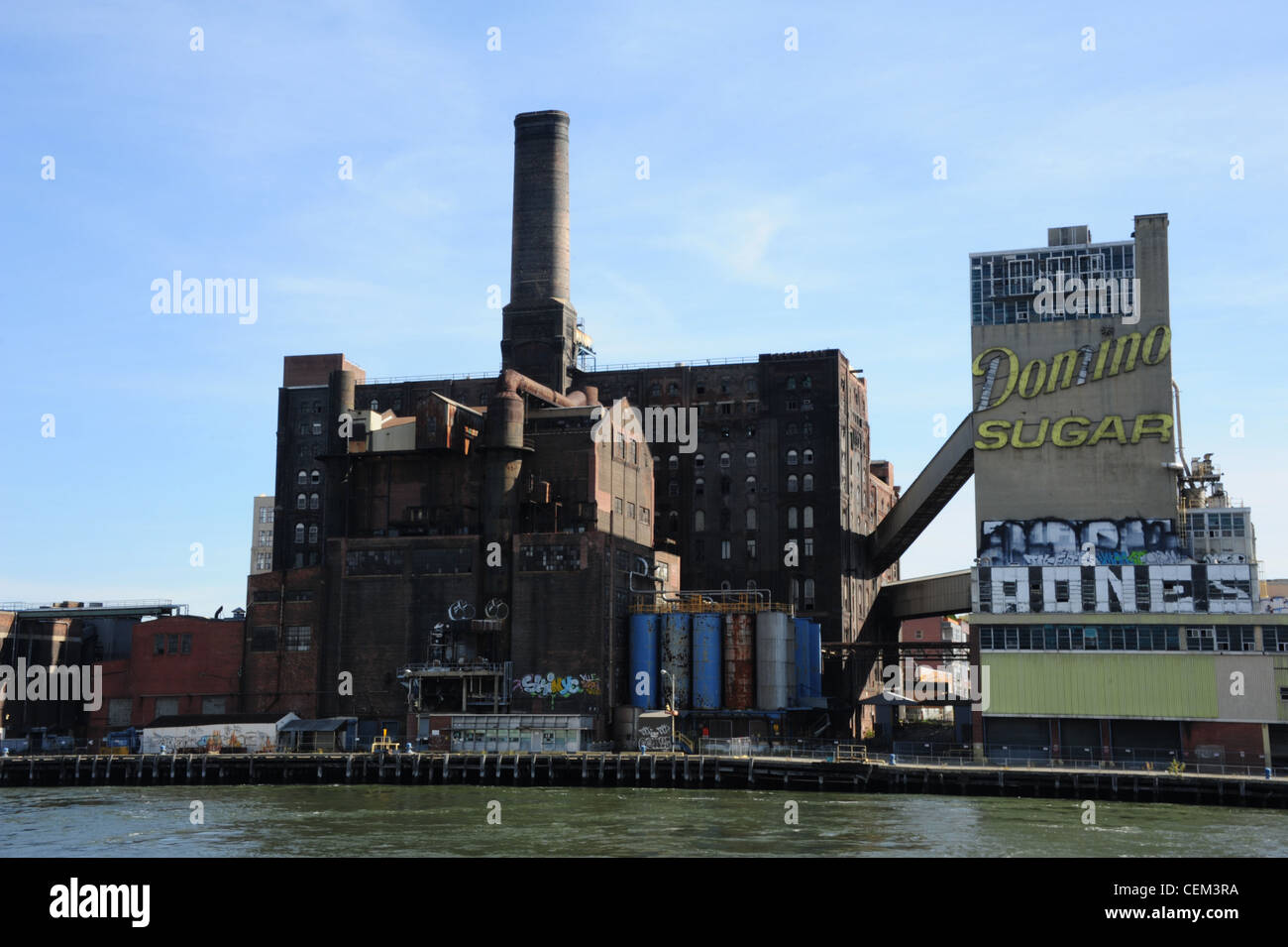 Blauer Himmelsblick vom East River, verfallene Gebäude Domino Zuckerraffinerie und Zeichen, Brooklyn Waterfront, Williamsburg, New York Stockfoto