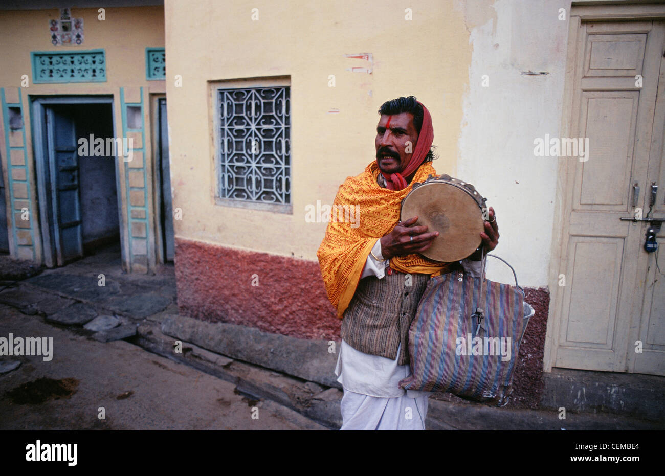 In einer Straße ein hinduistischer Mönch ("Sadhu") Musizieren und singen fromme Hymnen Sammle Nahrung und Geld (Indien) Stockfoto