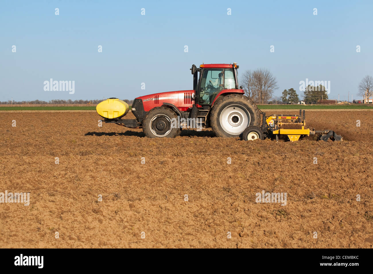 Ein Case IH Traktor und Feld implementieren beenden Bodenbearbeitung eines Feldes im späten Frühjahr für den Anbau von Baumwolle / Arkansas. Stockfoto