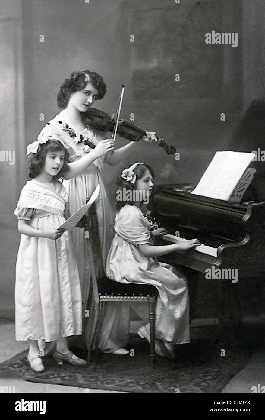 Ein Vintage Foto einer Frau mit 2 jungen Mädchen, die Musik, um 1910. Stockfoto