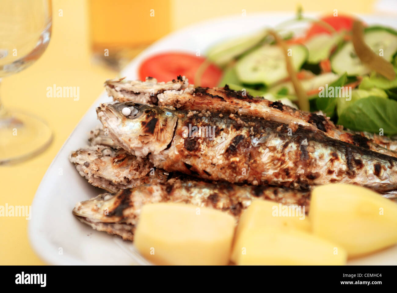 Gegrillte Sardinen mit Kartoffeln und Salat Stockfoto