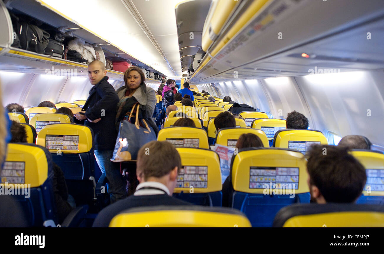 Ryanair-Kabine mit Passagieren im Fluggepäck in Regalen stehen Stockfoto