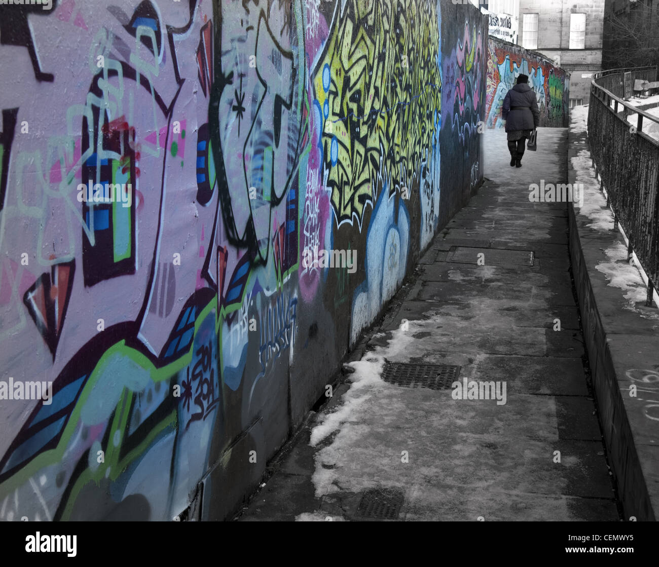 Edinburgh-Graffiti und alte Person Innenstadt Schottland. Eine einsame UK urbane Straßenszene in eisigen Winter, Schnee auf dem Boden. Stockfoto