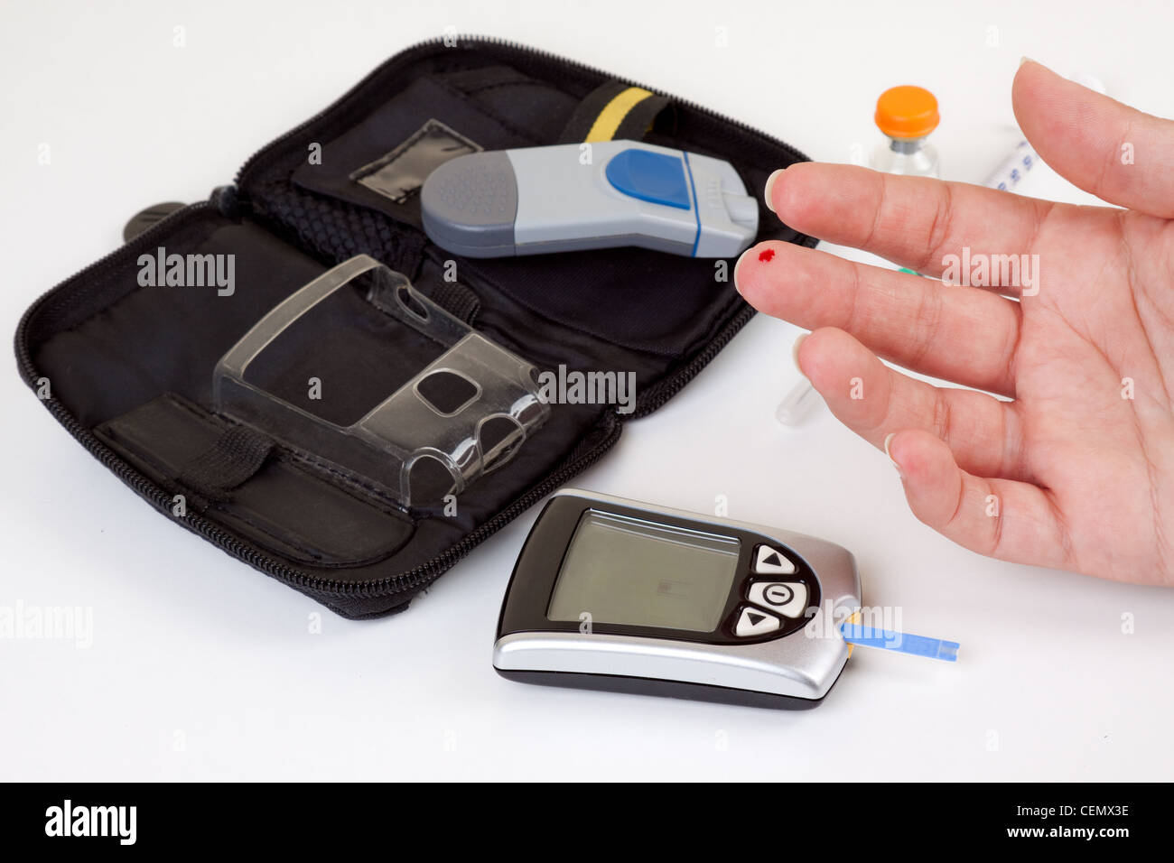 Diabetische Frau eine Blutuntersuchung mit der notwendigen Ausrüstung im Hintergrund zu tun. Stockfoto