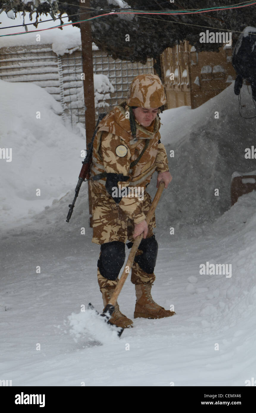 Ein rumänischer Soldat mit dem 280 mechanisierten Infanteriebataillon Schaufeln nach einer weiteren Nacht der schweren Schneefälle am Vorwärts Operating Base Bullard, Shah Freude, Afghanistan. Stockfoto