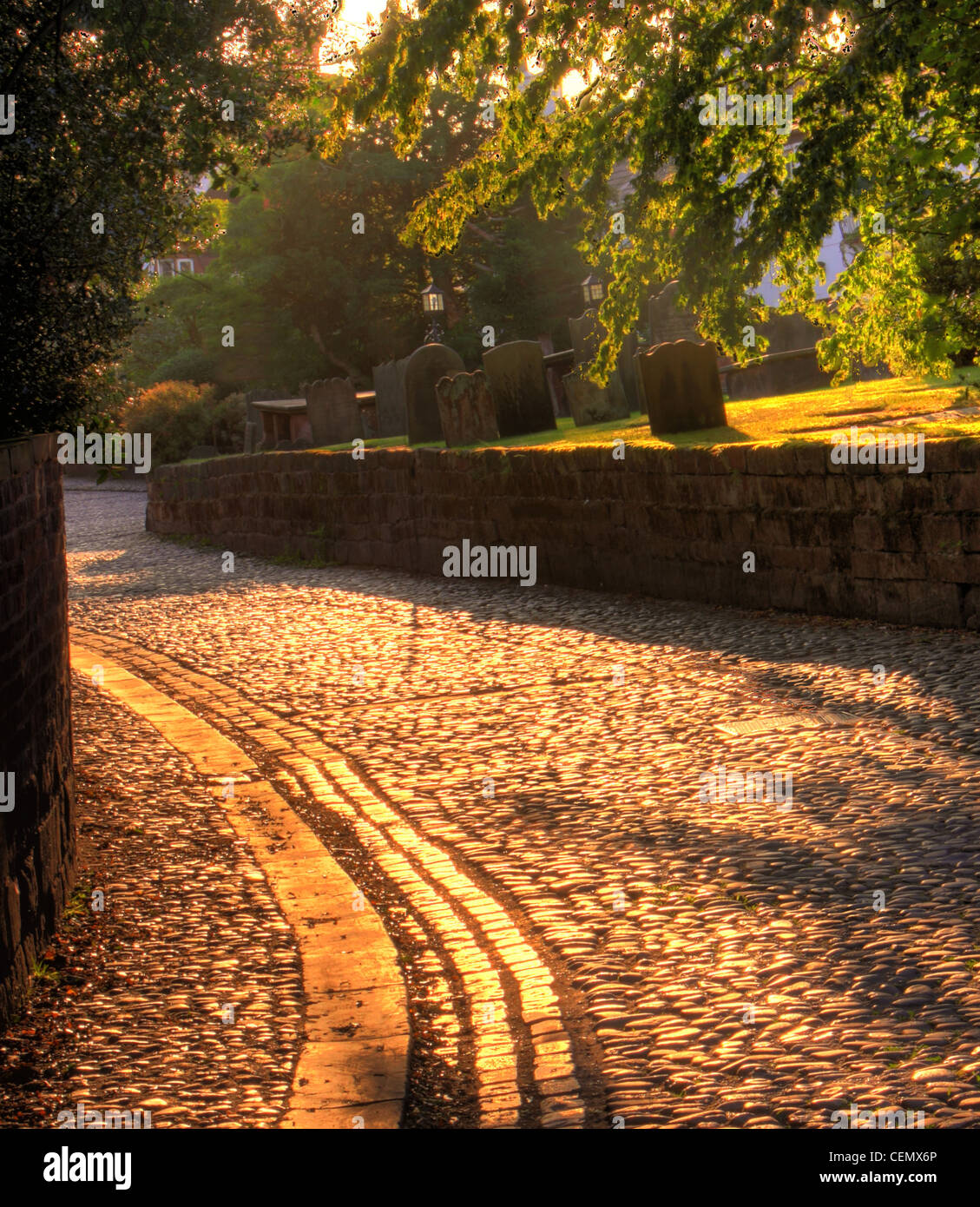 Der gepflasterte Bereich in Grappenhall Village, South Warrington bei Sonnenuntergang. (Church Lane, angrenzend an Str. Wilfrids Pfarrkirche) Stockfoto