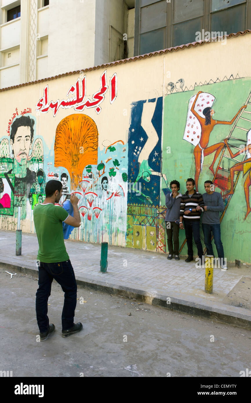 Jugendliche, posiert für Fotos neben Graffiti der Märtyrer der ägyptischen Revolution, neben dem Tahrirplatz, Kairo, Ägypten Stockfoto