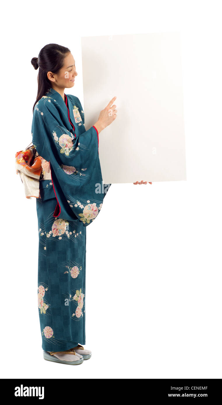 Volle Länge des japanischen Kimono Frau hält eine leere Plakatwand mit textfreiraum für Text auf weißem Hintergrund isoliert Stockfoto