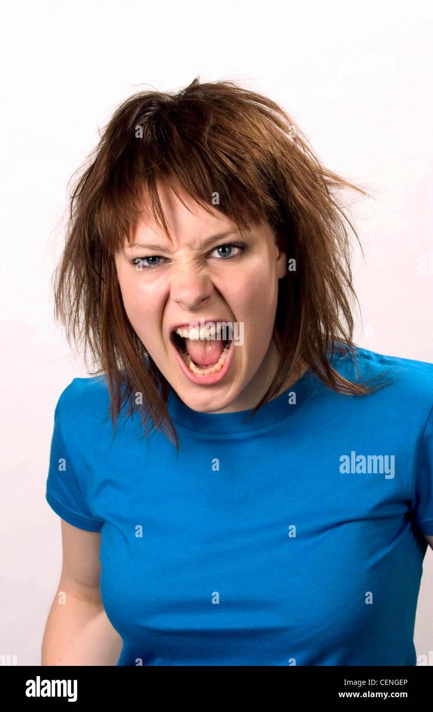 Weibliche Schulter brünette Haare durcheinander, tragen blaue t-Shirt auf Kamera Mund offen zeigt Zähne Gesicht verschraubt Stockfoto
