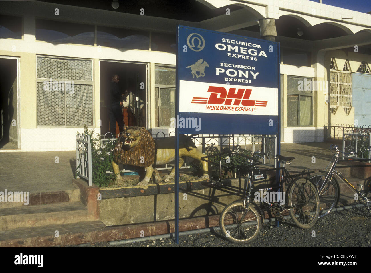 Securicor Omega Express und DHL Worldwide Express ländlichen Büro Naivasha Stadt Kenia Afrika mit Fahrrädern geparkt und Löwenstatue Stockfoto
