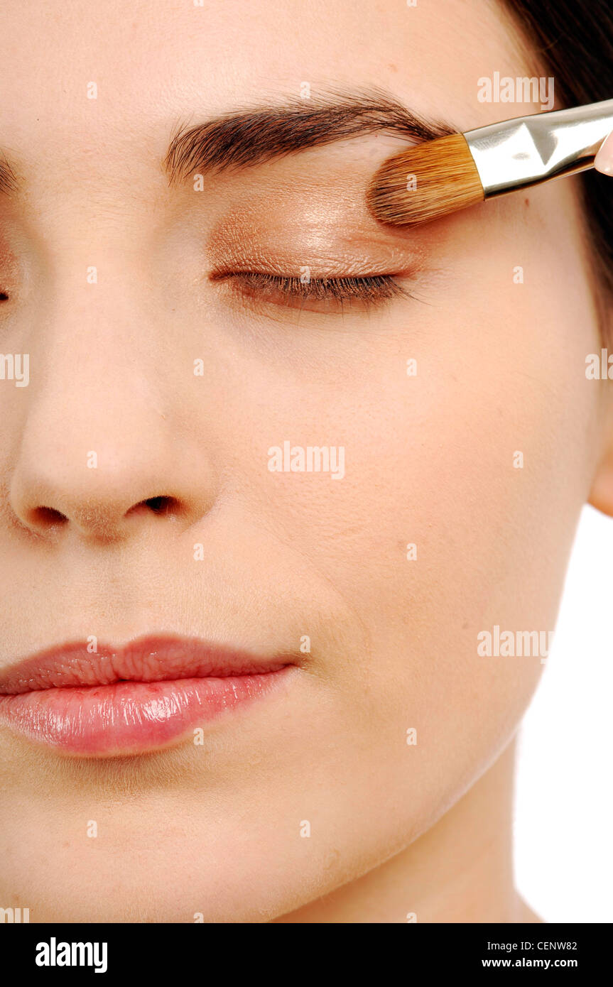 Nahaufnahme eines weiblichen Anwendung Pfirsich Lidschatten auf geschlossenen Augenlider Stockfoto